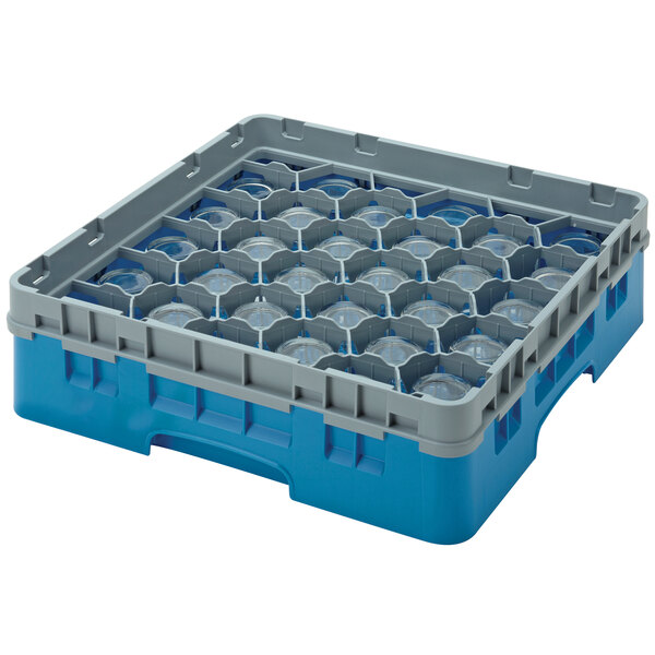 A teal plastic Cambro glass rack with clear glass compartments inside.