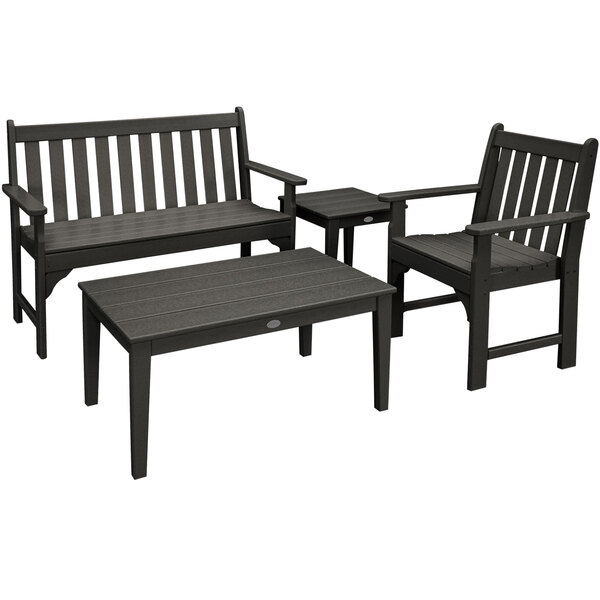 A black outdoor patio set with three black chairs and a black bench around a table.
