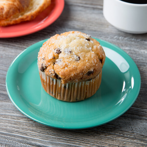 A muffin on a Diamond Mardi Gras narrow rim melamine plate next to a cup of coffee.
