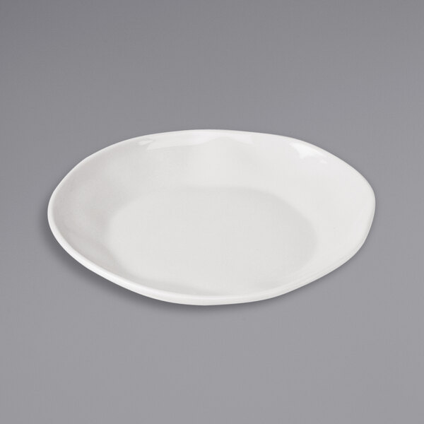 A Cal-Mil ivory melamine plate on a gray surface.