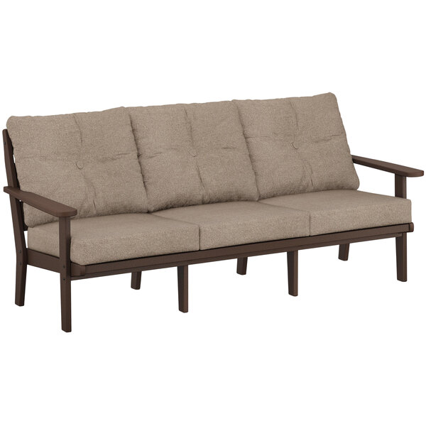 A POLYWOOD mahogany and burlap deep seating sofa with cushions on it.