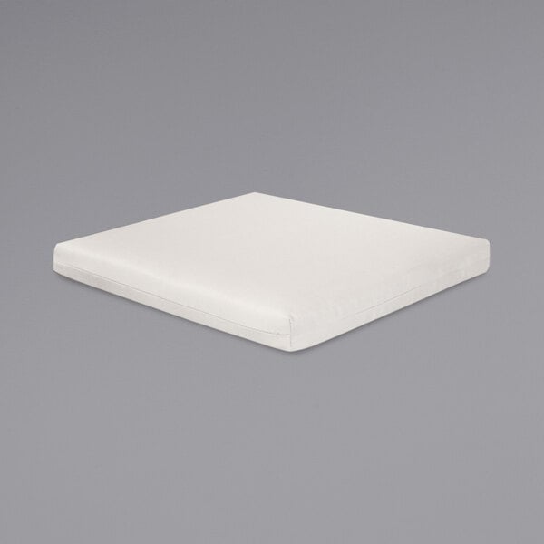 A white square POLYWOOD seat cushion on a gray surface.