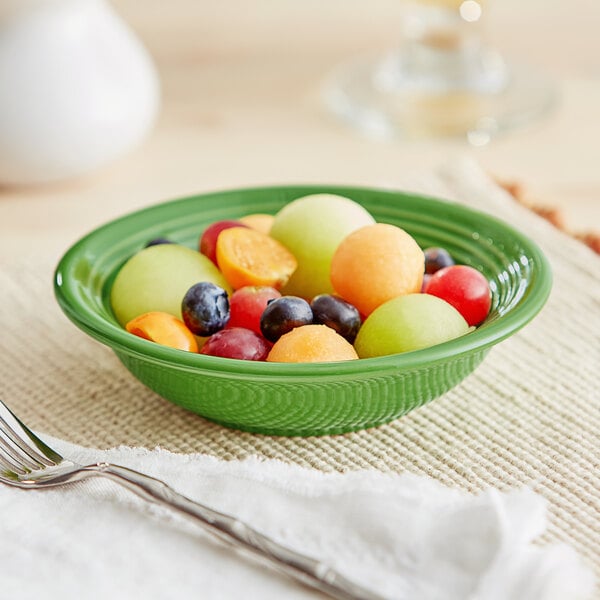 An Acopa Capri palm green stoneware bowl filled with fruit.