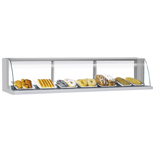 A Turbo Air stainless steel low profile top dry display case on a counter in a bakery with different types of pastries.