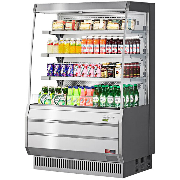 A Turbo Air stainless steel vertical open display case with drinks and beverages inside.
