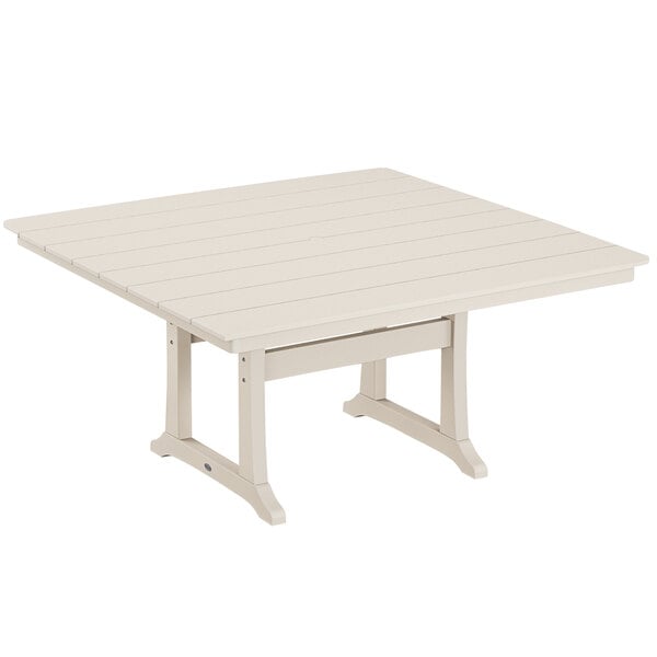 A white POLYWOOD dining table with a wooden top and trestle legs.