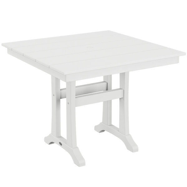 A POLYWOOD white dining table with wooden legs.