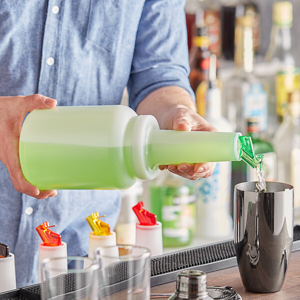 A person pouring liquid from a green Choice pour bottle into a cup.