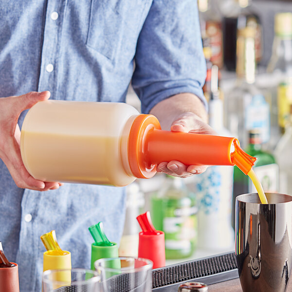 A person pouring liquid from a Choice orange pour bottle into a cup.