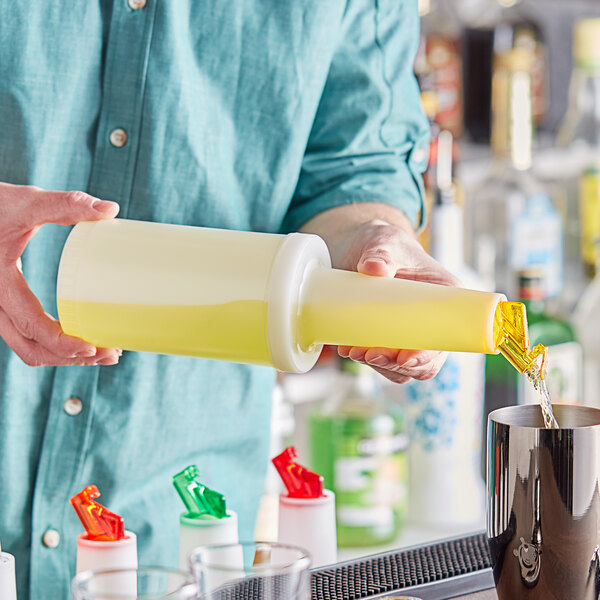 A person pouring yellow liquid from a Choice plastic container with a yellow flip top into a cup.