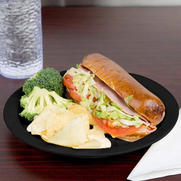 A Cambro black polycarbonate narrow rim plate with a sandwich and chips.