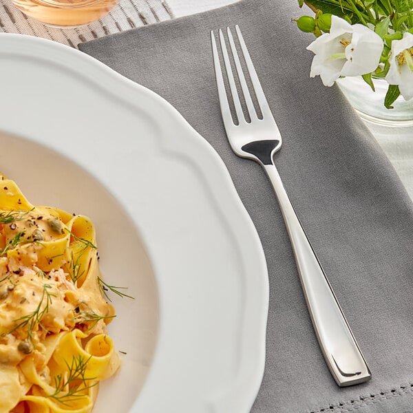 A plate of pasta with an Acopa Monte Bianco dinner fork on a table.