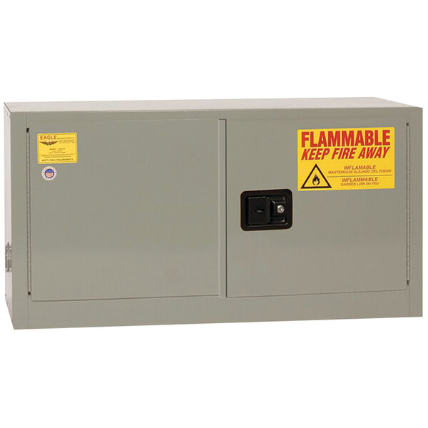 A grey Eagle Manufacturing safety cabinet with yellow and red warning labels.