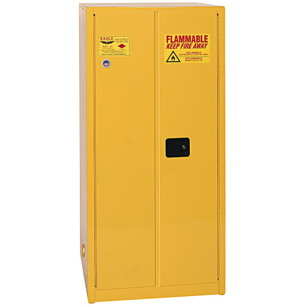 A yellow metal safety cabinet with black manual-closing doors.