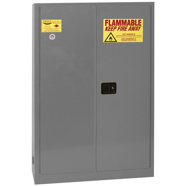 A grey metal Eagle safety cabinet with yellow and red warning labels.