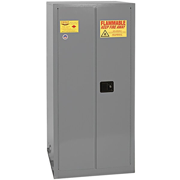 A grey metal Eagle Manufacturing safety cabinet with yellow labels.