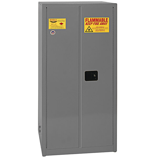 A gray steel Eagle Manufacturing safety cabinet with yellow labels.