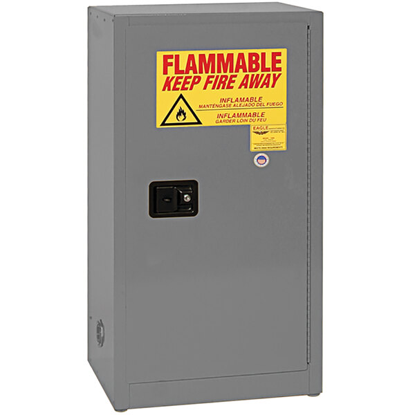 A grey metal Eagle Manufacturing safety cabinet with a yellow and red sign on the door.