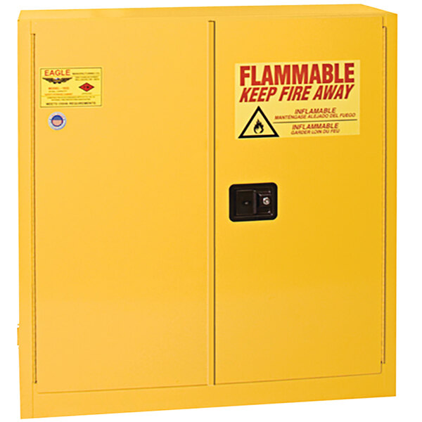 A yellow Eagle Manufacturing safety cabinet with a flammable sign and self-closing sliding door.