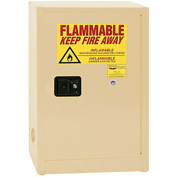 A tan metal Eagle Manufacturing safety cabinet with a yellow sign reading "Flammable Keep Away" and a red flame icon.