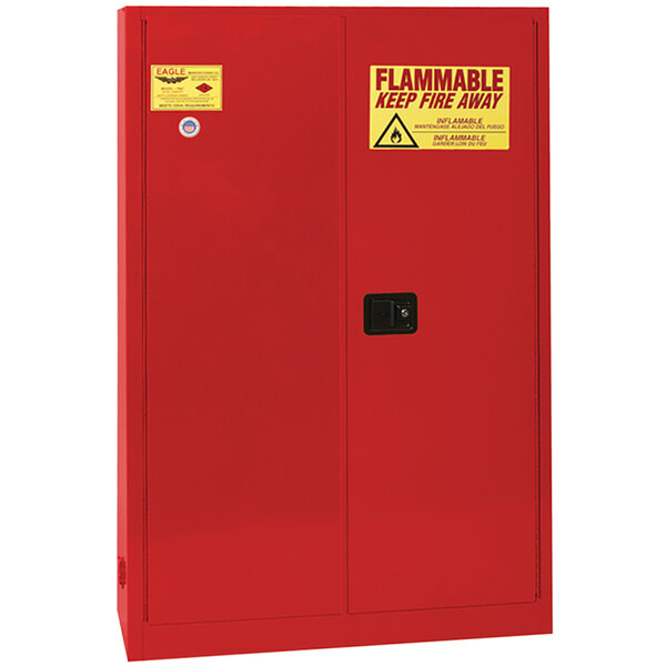 A red metal Eagle Manufacturing safety cabinet with yellow labels on the doors.