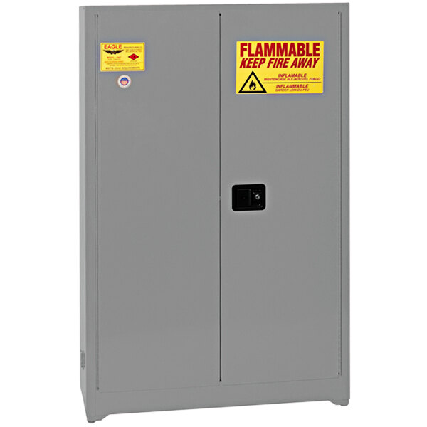 A grey Eagle Manufacturing safety cabinet with yellow and red warning labels.