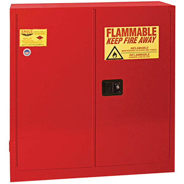 A red Eagle flammable liquid safety cabinet with a yellow sign.