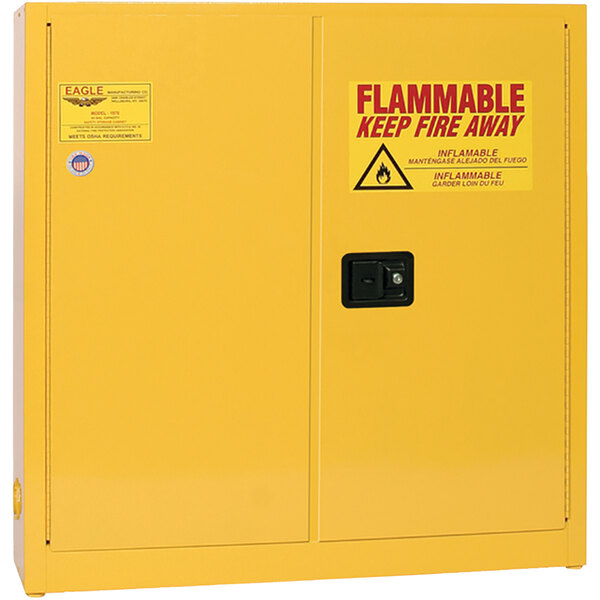 A yellow Eagle Manufacturing flammable liquid safety cabinet with a yellow and red warning sign.
