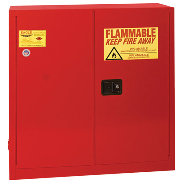A red Eagle Manufacturing safety cabinet with a yellow sign reading "flammable" and "keep away"