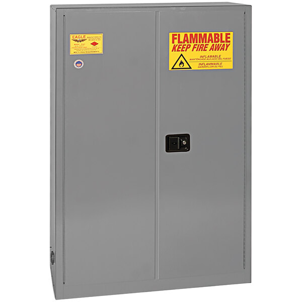A grey metal Eagle Manufacturing safety cabinet with yellow and red labels.