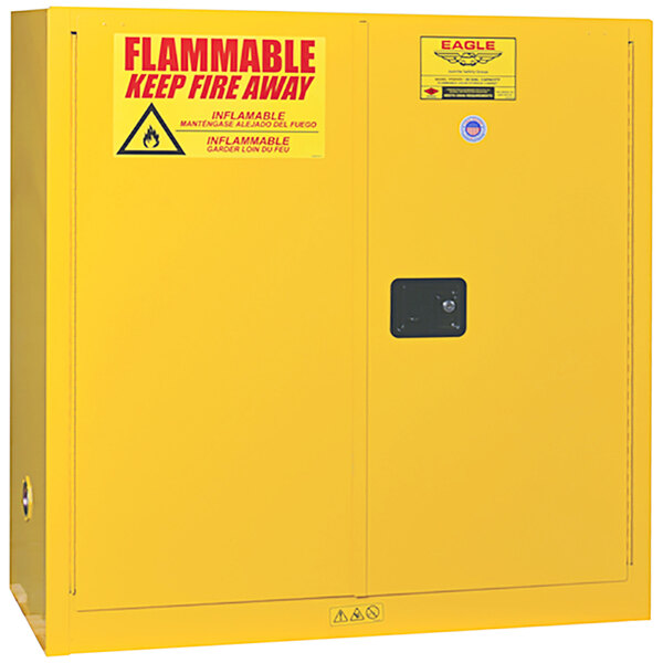 A yellow Eagle Manufacturing safety cabinet with a sign on it.