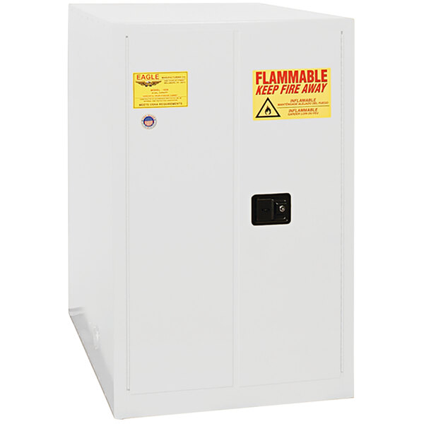 A white metal Eagle Manufacturing safety cabinet with a yellow and red warning label.
