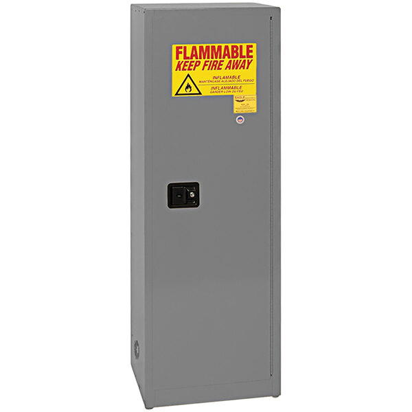 A grey metal Eagle Manufacturing safety cabinet with a yellow and red warning sign.