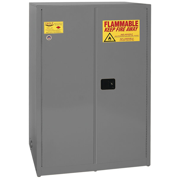 A gray Eagle safety cabinet with yellow and red warning labels.
