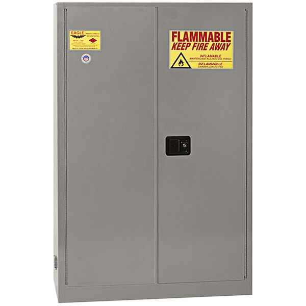 A grey metal Eagle Manufacturing safety cabinet with yellow and red warning labels.