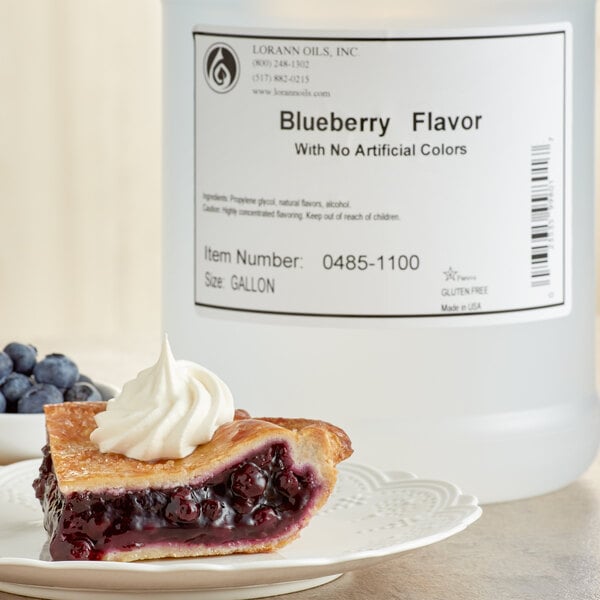 A slice of blueberry pie with whipped cream and blueberries on a white plate.