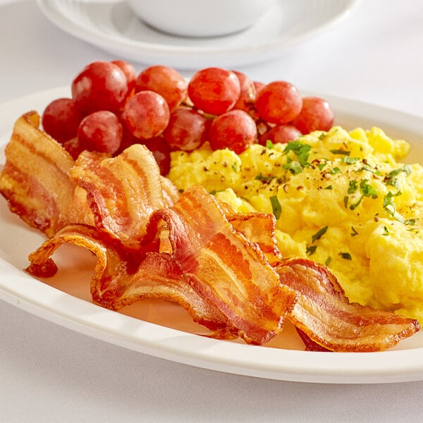 A plate of scrambled eggs with Warrington Farm Meats smoked bacon and grapes.