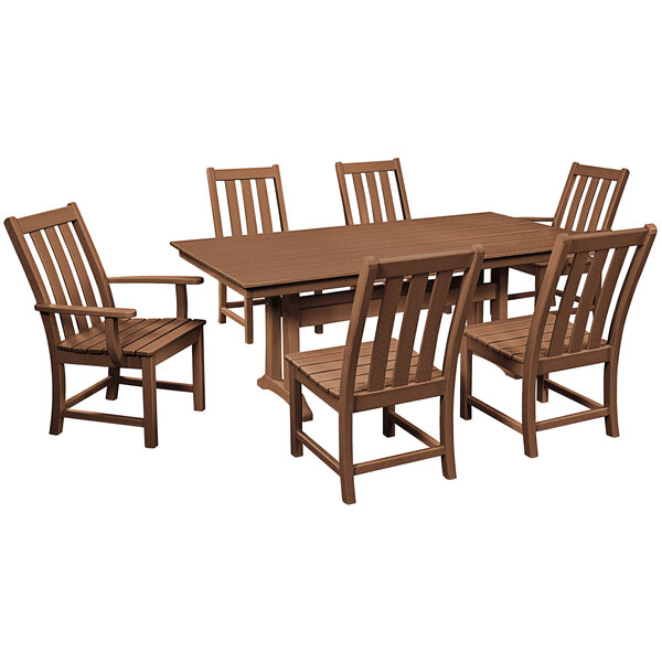 A POLYWOOD teak dining table with six chairs on a outdoor patio.