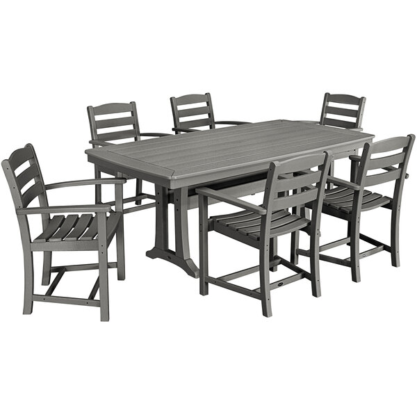 A POLYWOOD slate grey outdoor dining table with six arm chairs on a patio.