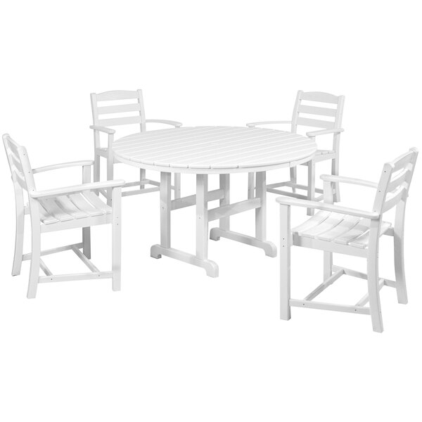 A white POLYWOOD table with a round top and four arm chairs.