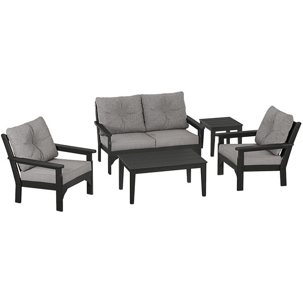 A grey POLYWOOD outdoor furniture set with black accents including a table, chairs, and a couch.