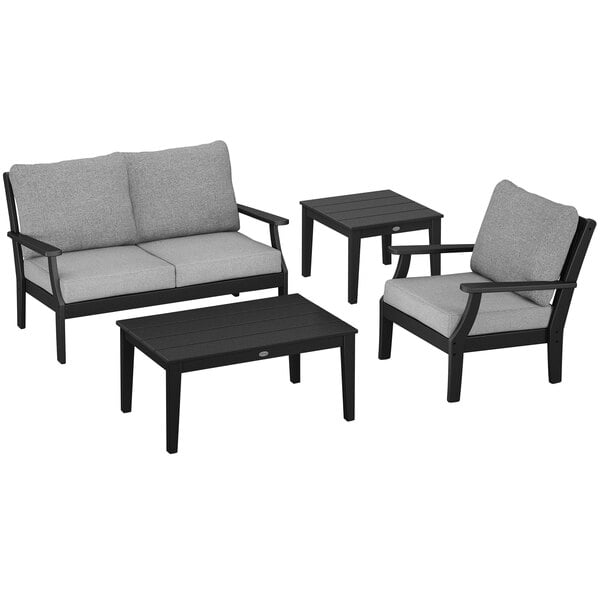 A black and grey POLYWOOD outdoor seating set with chairs, a settee, and tables.