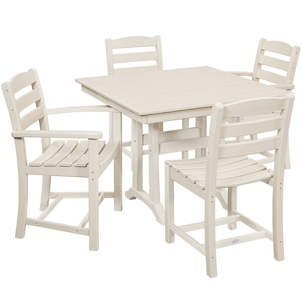 A POLYWOOD white farmhouse dining table with four white chairs.