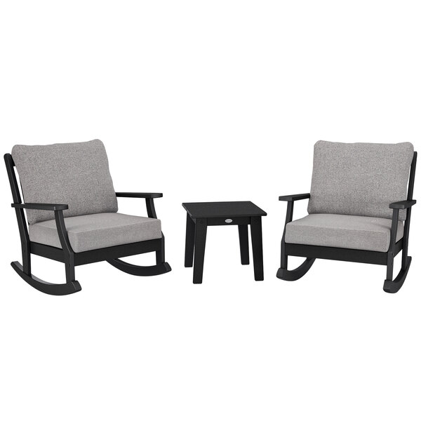 Two black POLYWOOD rocking chairs with a grey table.