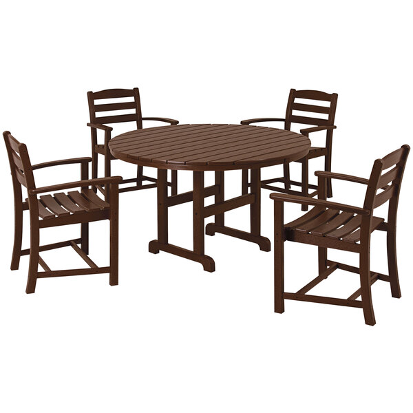 A POLYWOOD mahogany dining table with four arm chairs on an outdoor patio.