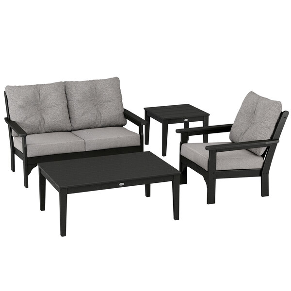 A group of POLYWOOD patio furniture with black frames and grey cushions, including a table.