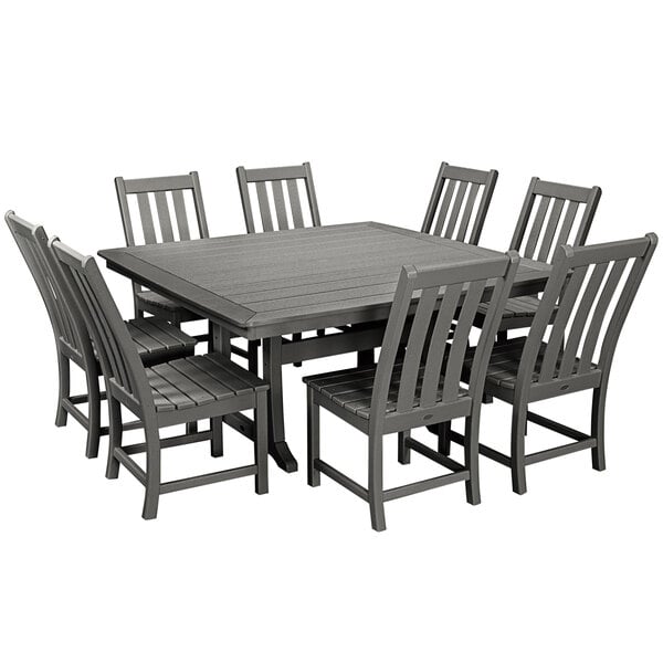 A POLYWOOD slate grey dining table with chairs on an outdoor patio.