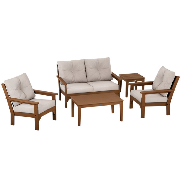 A POLYWOOD teak and dune burlap deep seating chair and table set with white cushions.