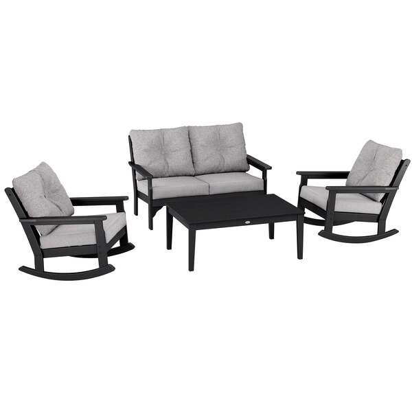 A black and grey POLYWOOD outdoor furniture set with a table and rocking chairs.
