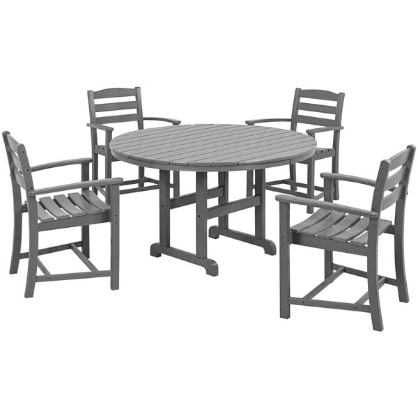 A POLYWOOD La Casa Cafe round dining table with a slate grey top and four arm chairs around it.